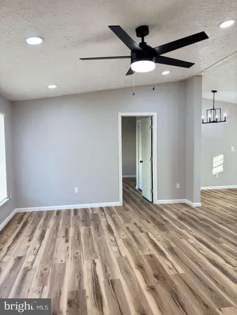 a view of a livingroom with a ceiling fan and wooden floor
