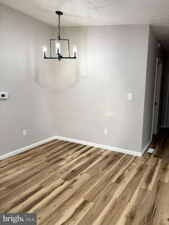 a view of a room with a ceiling fan and wooden floor