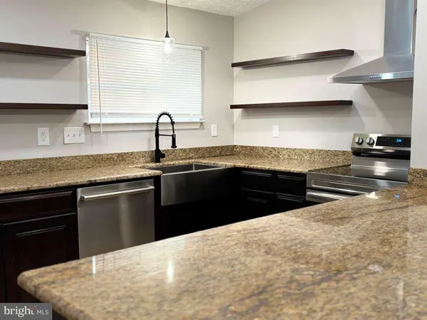 a kitchen with stainless steel appliances granite countertop a sink stove and cabinets
