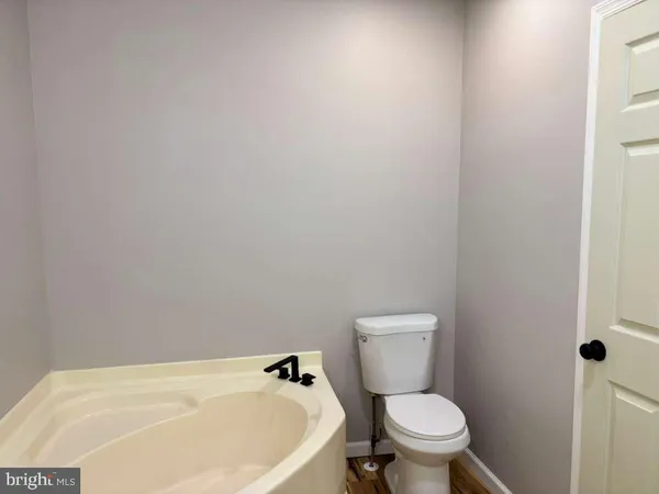 a white toilet sitting next to a white tub