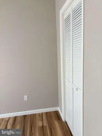 a view of a room with wooden floor and white walls
