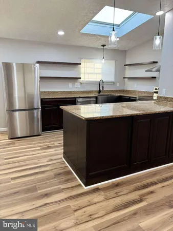 a kitchen with stainless steel appliances granite countertop a sink and a stove
