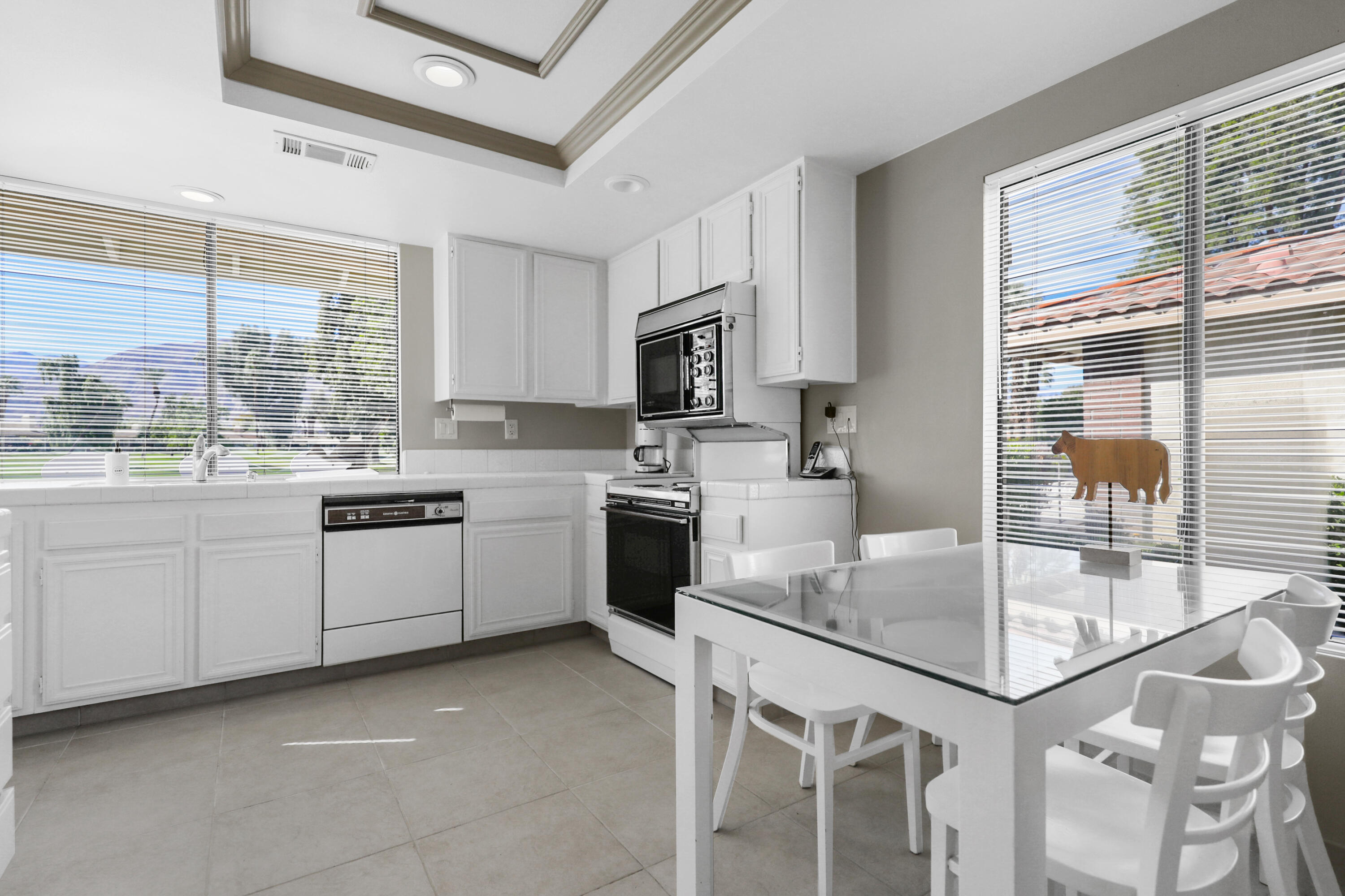 175 Gran Via Palm Desert, CA 92260 - Photo 11 of 36 a kitchen with granite countertop a sink appliances cabinets and a counter top space