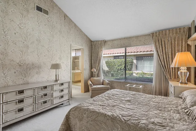 a bedroom with a bed and a dresser with the large mirror