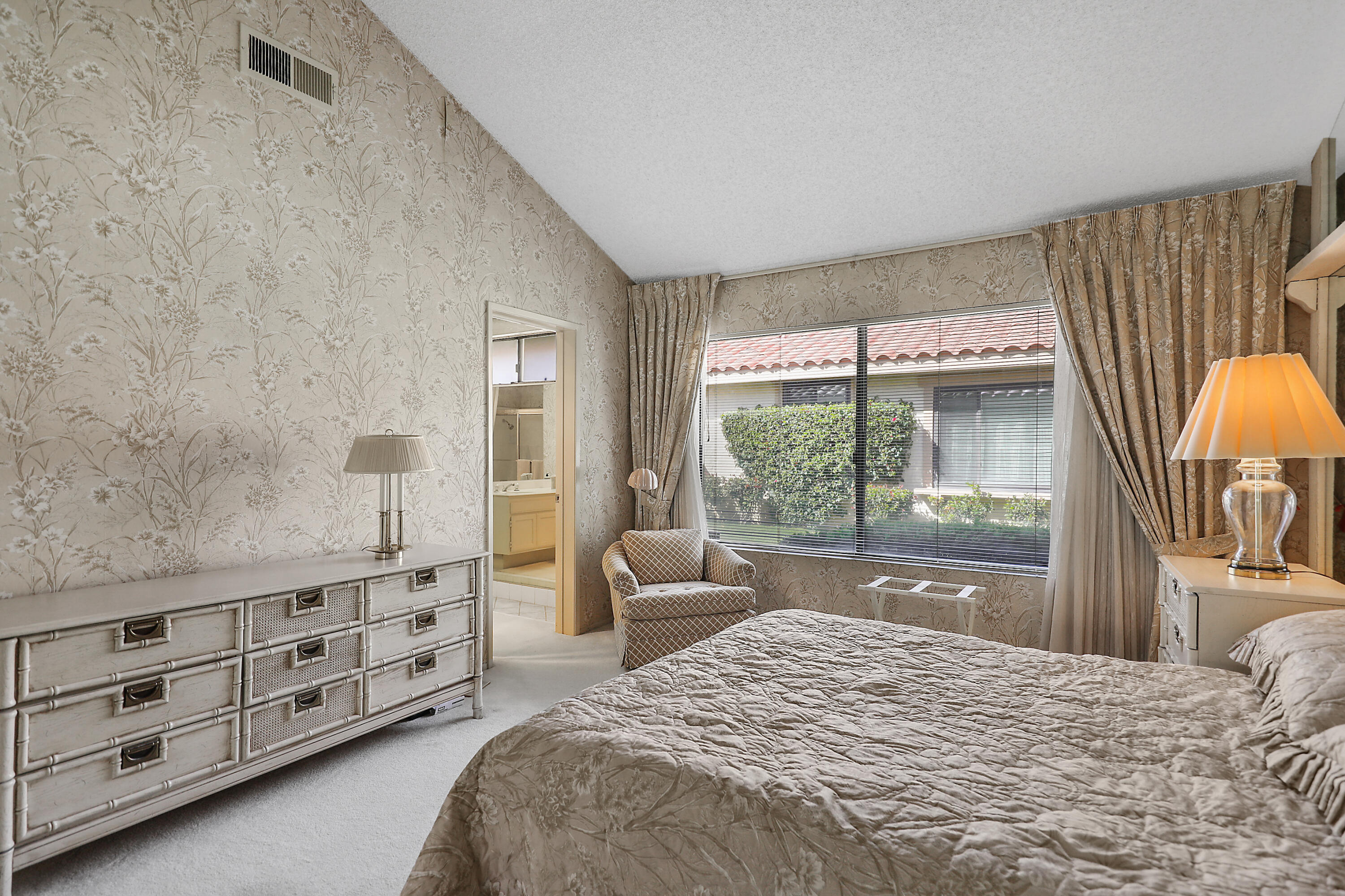 175 Gran Via Palm Desert, CA 92260 - Photo 21 of 36 a bedroom with a bed and a dresser with the large mirror