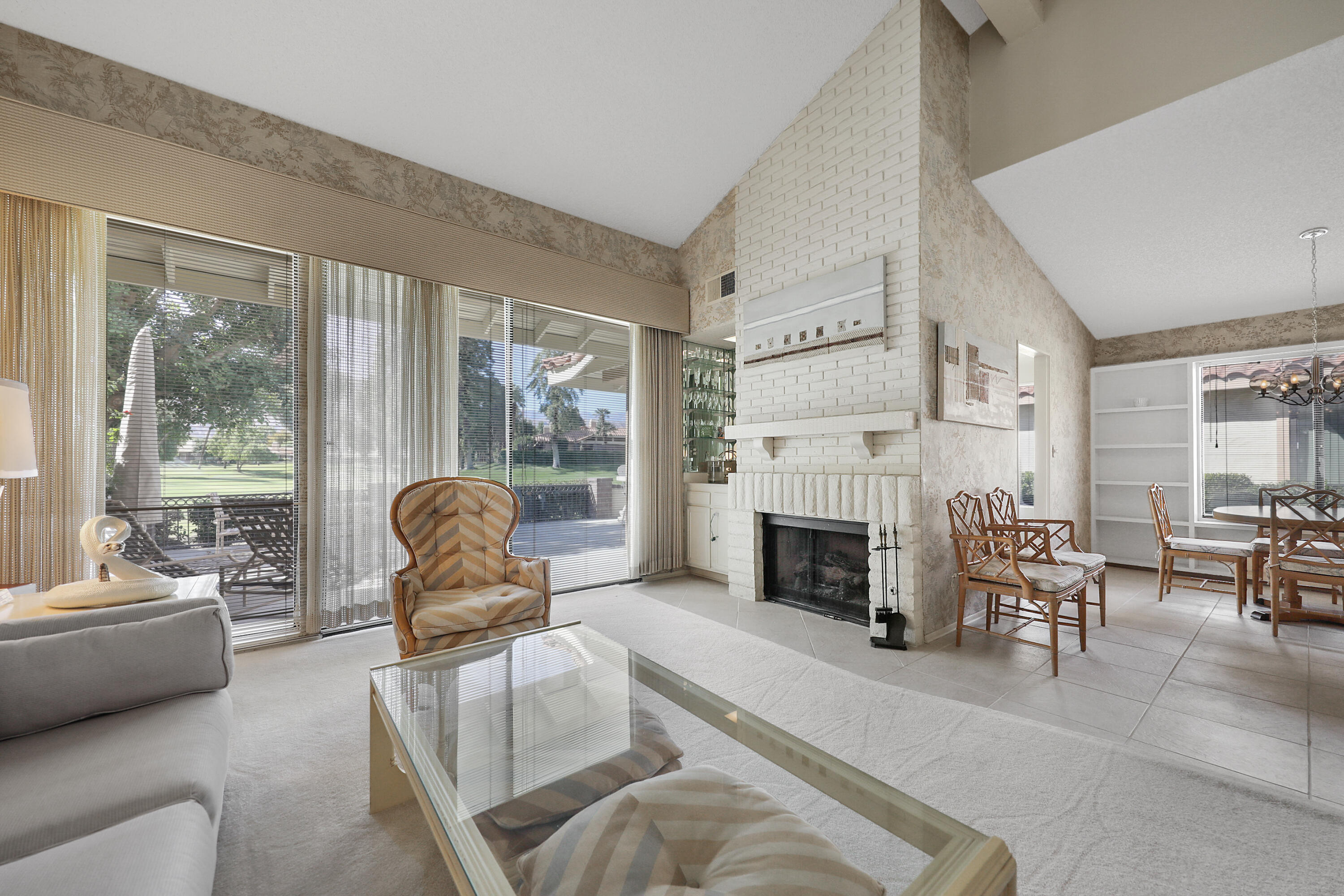 175 Gran Via Palm Desert, CA 92260 - Photo 8 of 36 a living room with furniture a fireplace and large windows