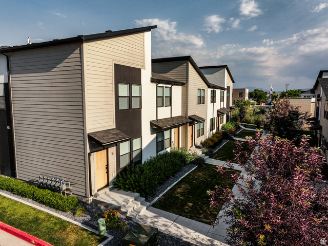 220 Spring Creek Parkway Providence, UT 84332 - Photo 2 of 26 Contemporary townhome exterior featuring multi-toned siding, black window frames, and covered entryways