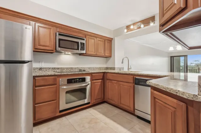 a kitchen with stainless steel appliances granite countertop a sink stove and microwave
