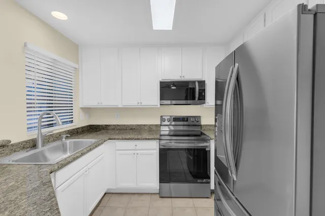 a kitchen with granite countertop a sink and a stove top oven