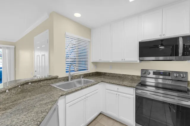a kitchen with granite countertop sink and window