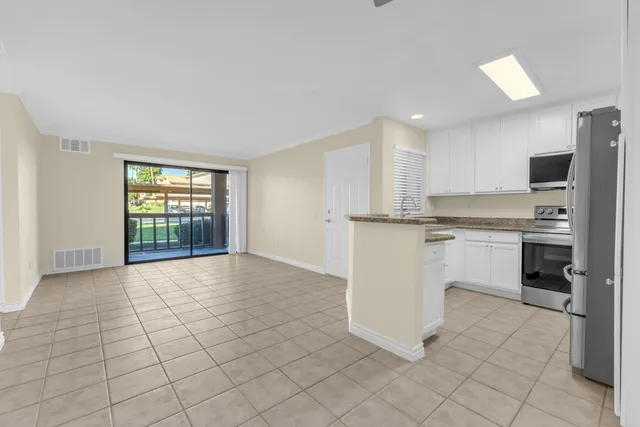 a view of an empty room with a kitchen