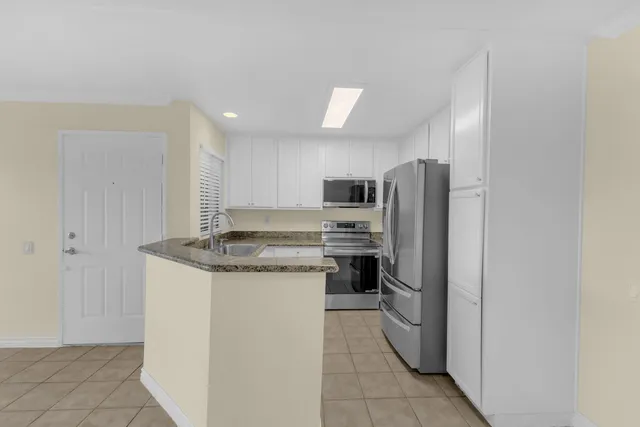 a kitchen with stainless steel appliances granite countertop a refrigerator and a stove top oven