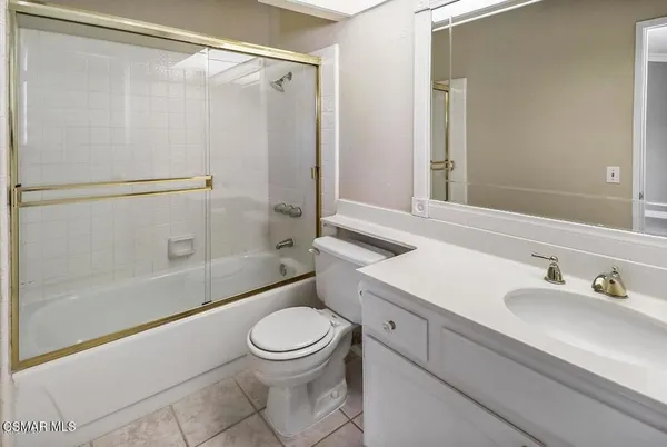 a bathroom with a sink a mirror toilet and bathtub