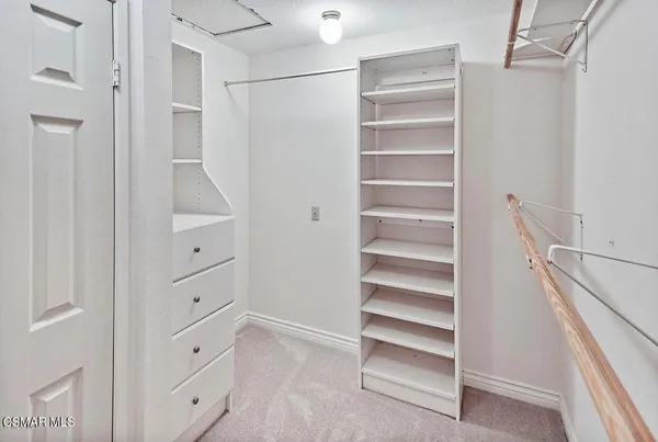 a view of walk in closet with empty racks