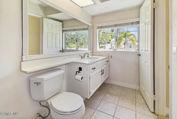a bathroom with a sink toilet and window