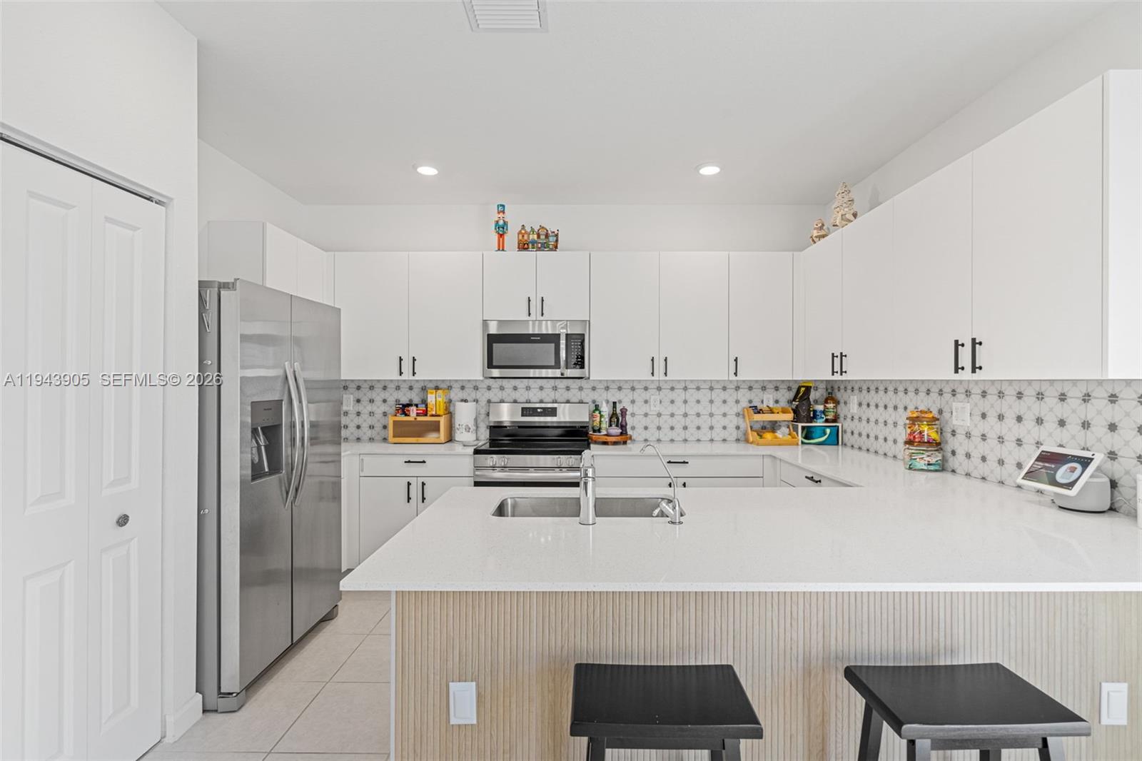 16276 Southwest 291st Street Homestead, FL 33033 - Photo 2 of 22 a kitchen with stainless steel appliances a refrigerator a sink a stove and white cabinets