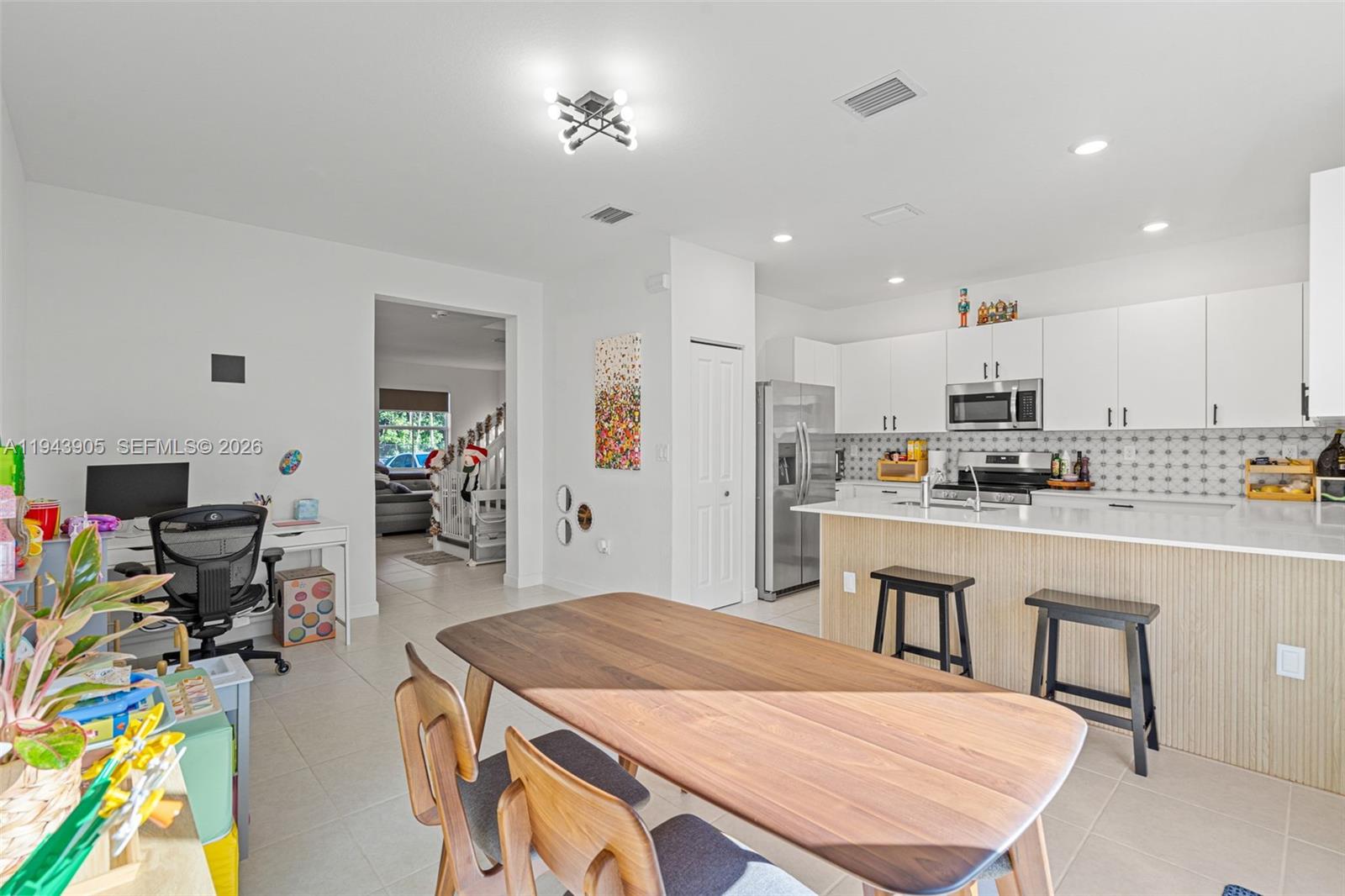 16276 Southwest 291st Street Homestead, FL 33033 - Photo 4 of 22 a room with stainless steel appliances kitchen island granite countertop a dining table chairs and a refrigerator a sink
