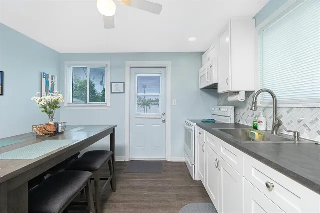 a kitchen with stainless steel appliances white cabinets white stove a microwave and a refrigerator