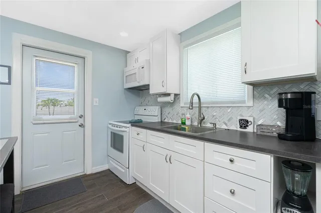 a view of a kitchen with workspace and wooden floor
