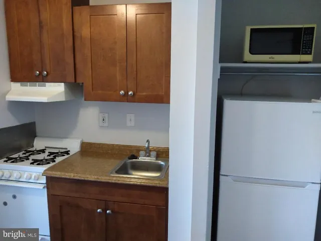 a kitchen with a refrigerator and a stove top oven