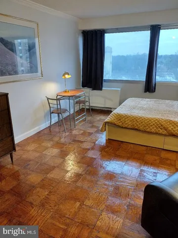 a living room with a bed furniture and a large window