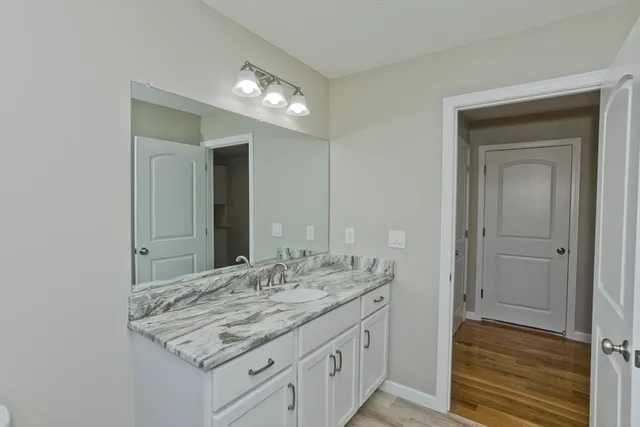 a bathroom with a granite countertop sink and a mirror