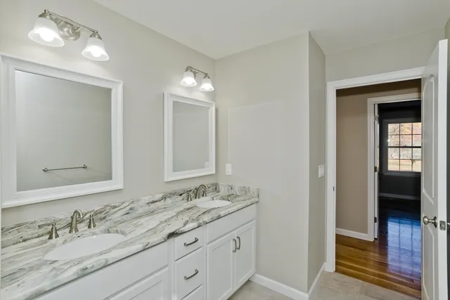 a bathroom with a granite countertop sink double vanity and a mirror