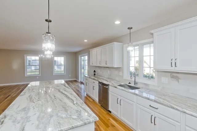 a kitchen with granite countertop a sink window and cabinets