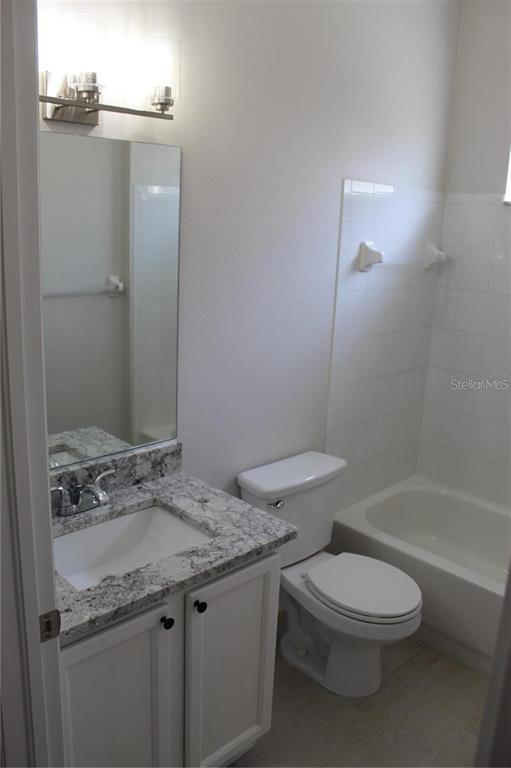 12503 Sparkleberry Road Tampa, FL 33626 - Photo 5 of 8 a bathroom with a granite countertop toilet a sink and a mirror
