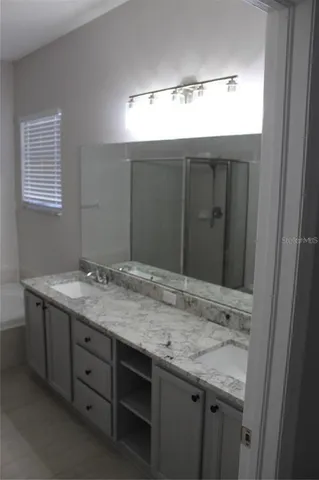 a bathroom with a granite countertop sink and a mirror