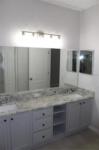a bathroom with a granite countertop sink and a mirror