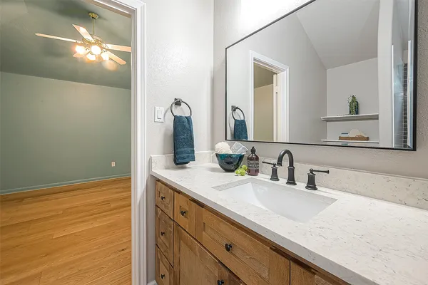 a bathroom with a granite countertop sink and a mirror