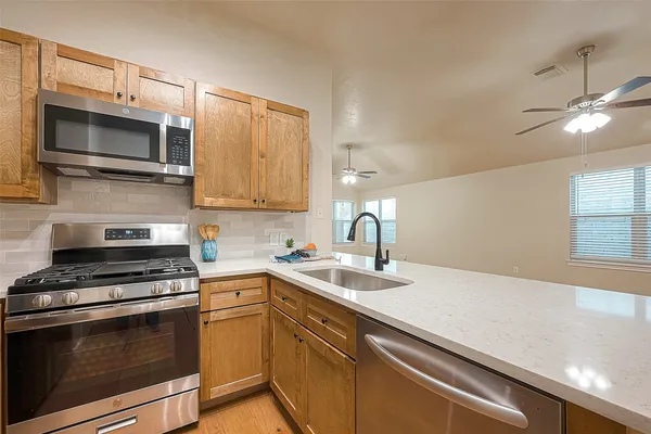 a kitchen with stainless steel appliances a stove microwave and sink