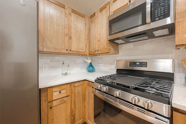 a kitchen with stainless steel appliances granite countertop a stove and a microwave