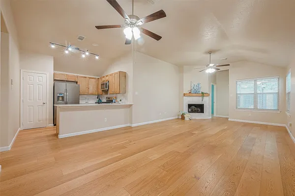 a view of a kitchen with kitchen island wooden floor and a ceiling fan