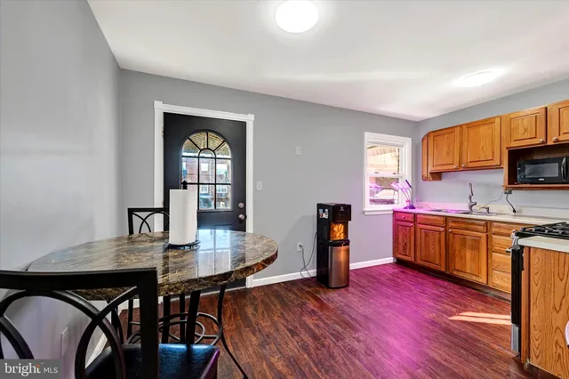 a kitchen with sink wooden floor dining table and chairs