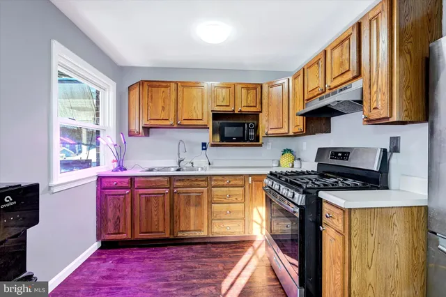 a kitchen with stainless steel appliances granite countertop a stove a sink dishwasher and a microwave
