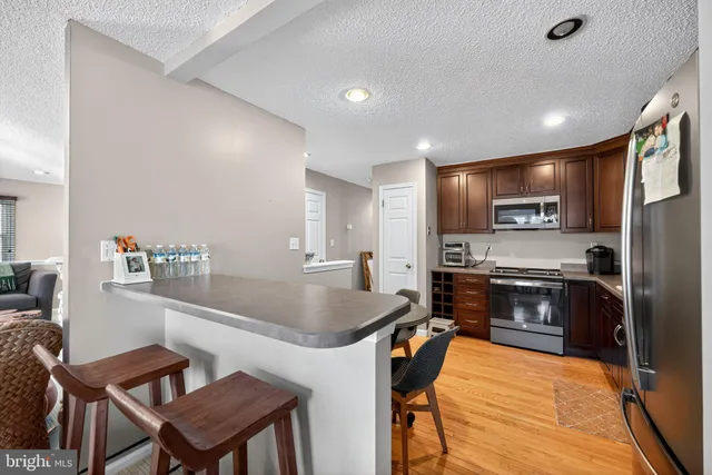 a kitchen with a table chairs refrigerator and microwave