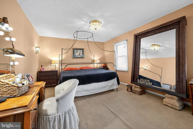 a bedroom with a bed and a mirror on the dresser