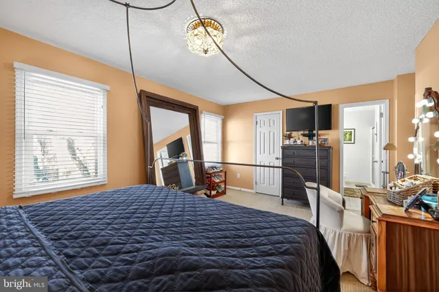 a bedroom with a bed a window and dresser