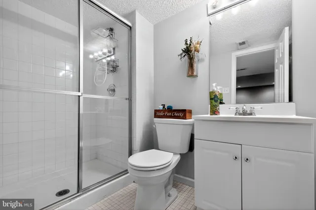 a bathroom with a granite countertop toilet a sink and a mirror
