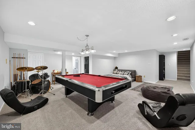 a living room with furniture and a pool table
