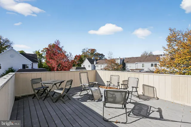 a view of a roof deck with table and chairs