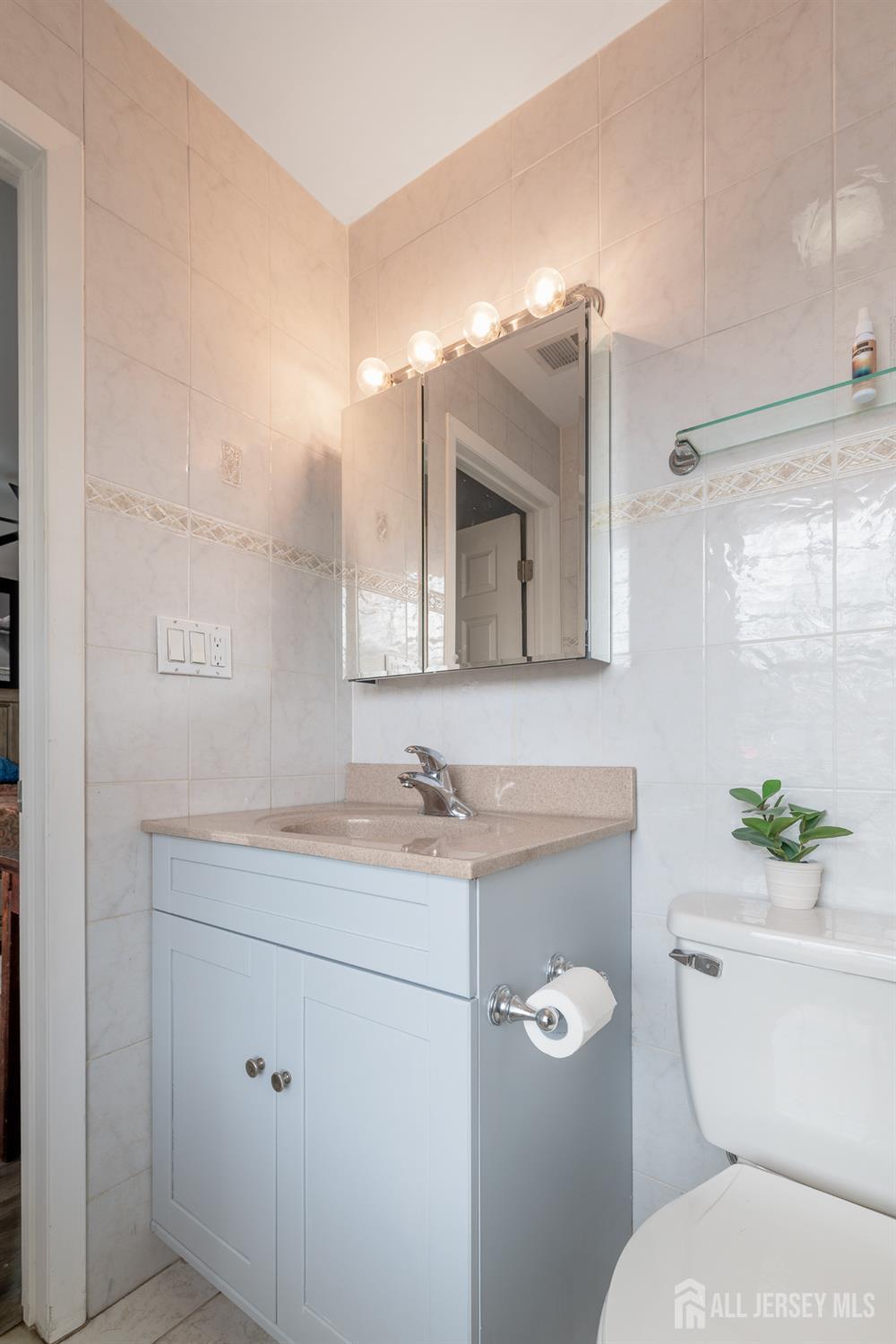 105 Neilly Court Old Bridge, NJ 08857 - Photo 13 of 24 a bathroom with a toilet a sink and mirror
