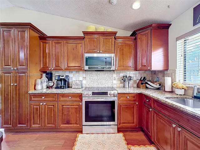 a kitchen with stainless steel appliances granite countertop wooden cabinets a sink and dishwasher