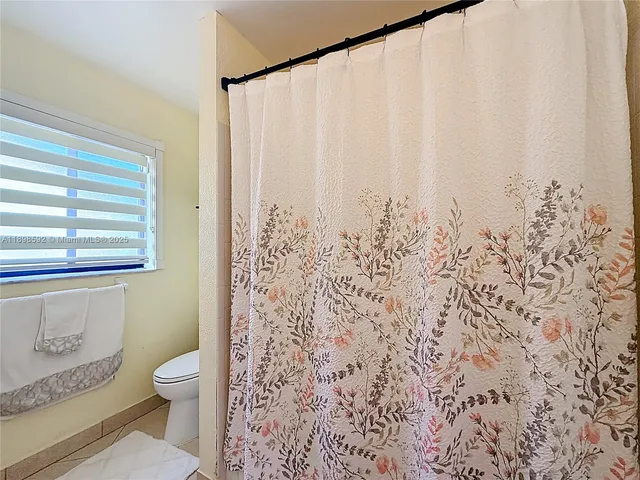 a bathroom with a toilet and a shower curtain