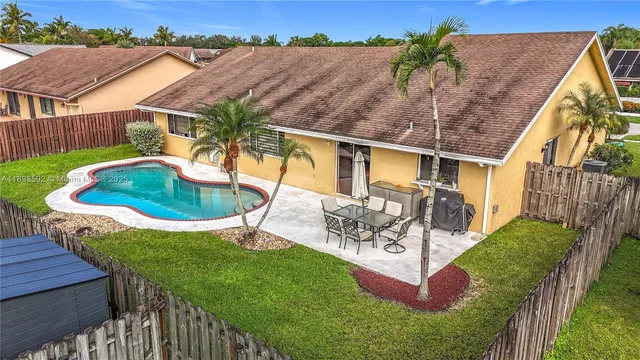 a view of a backyard with table and chairs potted plants with wooden fence