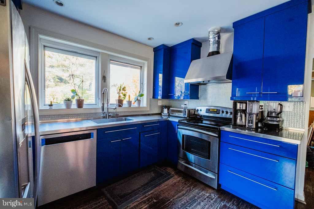 5232 Macomb Street Northwest Washington, DC 20016 - Photo 4 of 5 a kitchen with stainless steel appliances granite countertop a stove a sink dishwasher and a refrigerator