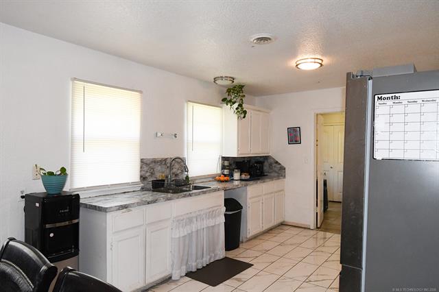 107903 South 4570 Road Sallisaw, OK 74955 - Photo 16 of 35 Kitchen featuring white cabinetry, grey marble-finish countertops, and a tile floor