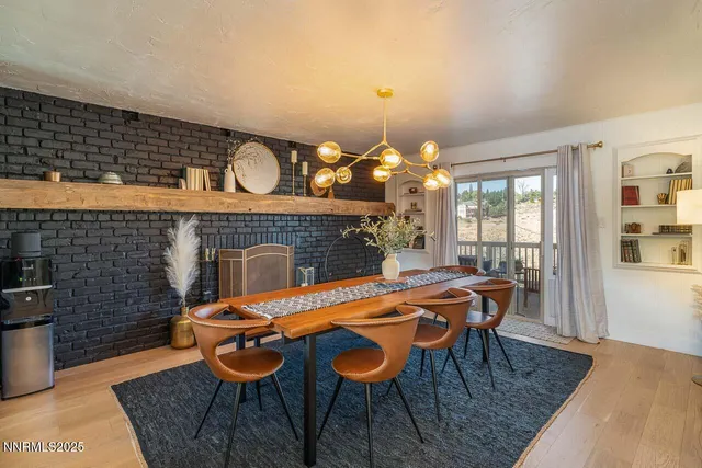 a kitchen with stainless steel appliances kitchen island granite countertop a table chairs and a refrigerator